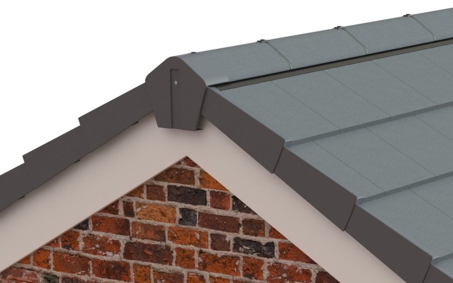 Close-up of a roof corner with grey tiles and brickwork beneath.