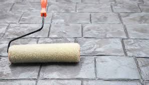Paint roller on a textured stone surface.